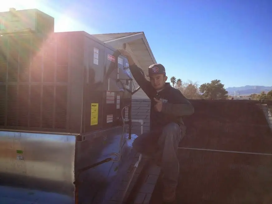 HVAC technician performing Boiler Repair on a rooftop unit in Clinton